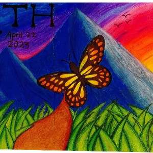 A butterfly flys over a green field with mountains in the background.